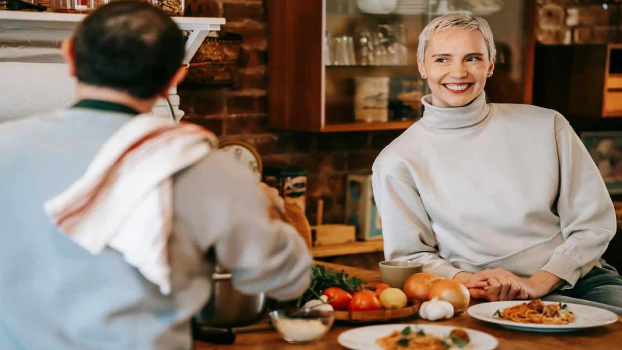 A woman smiling at her husband in the kitchen