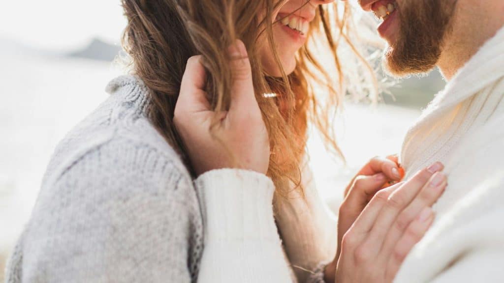 A close-up of a smiling couple sharing an intimate moment.