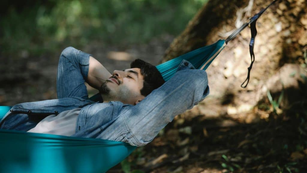 A man relaxing in a hammock outdoors.