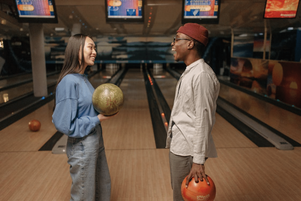 A man and a woman holding bowling balls