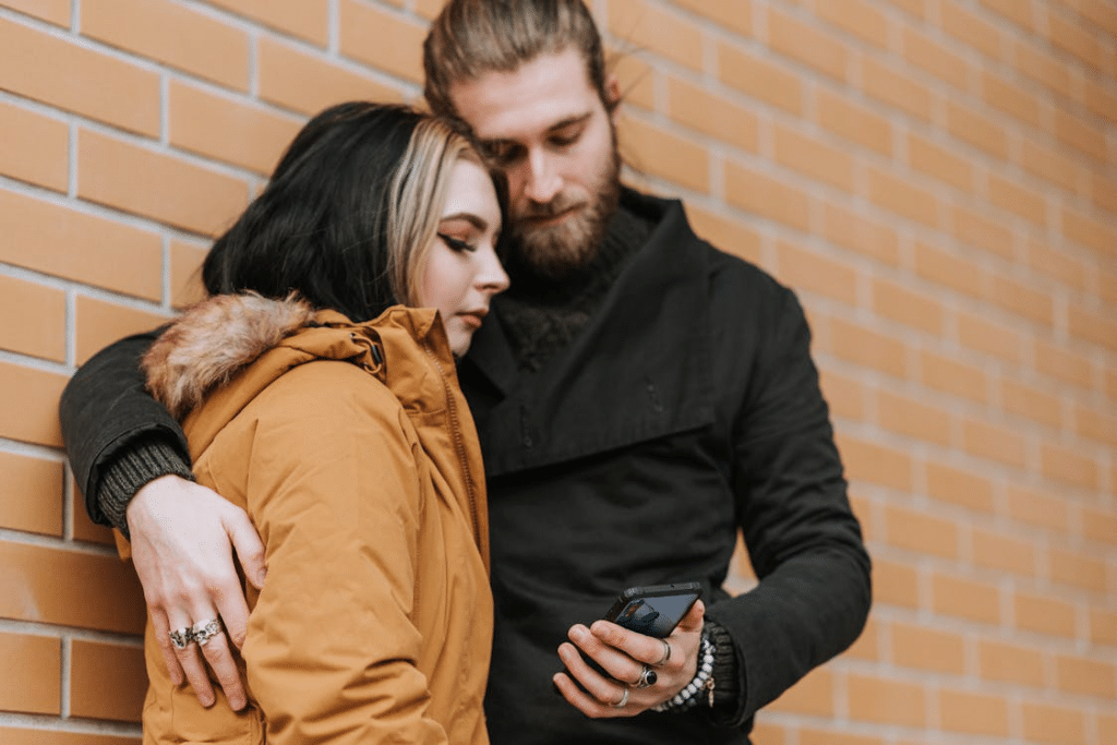 Crop couple browsing internet on smartphone on street