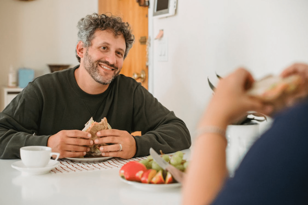 Cheerful bearded man having breakfast with wife