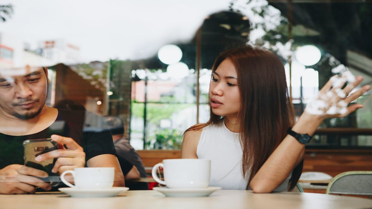 A man using his phone while on a date 