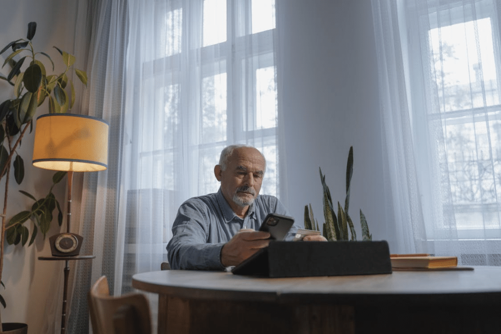 A Low Angle Shot of an Elderly Man Using His Mobile Phone