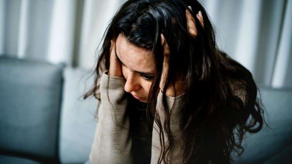 A woman sitting with her head in her hands.