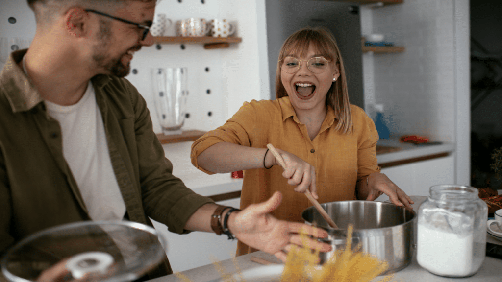 A couple laughing together in the kitchen