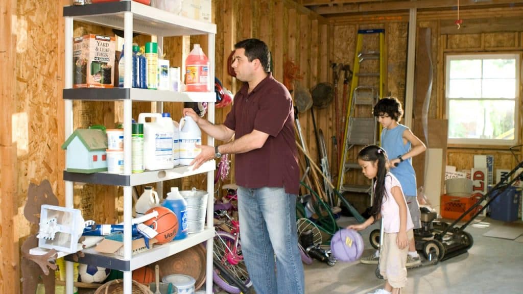 Man putting a plastic can on a brown wooden shelf.