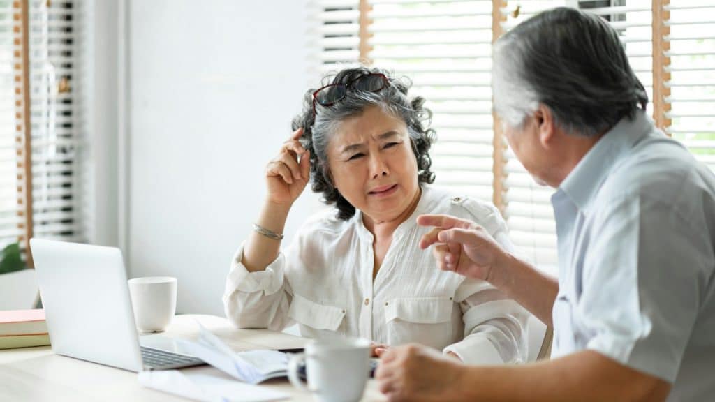 A stressed old couple having problems talk about family financial crises.