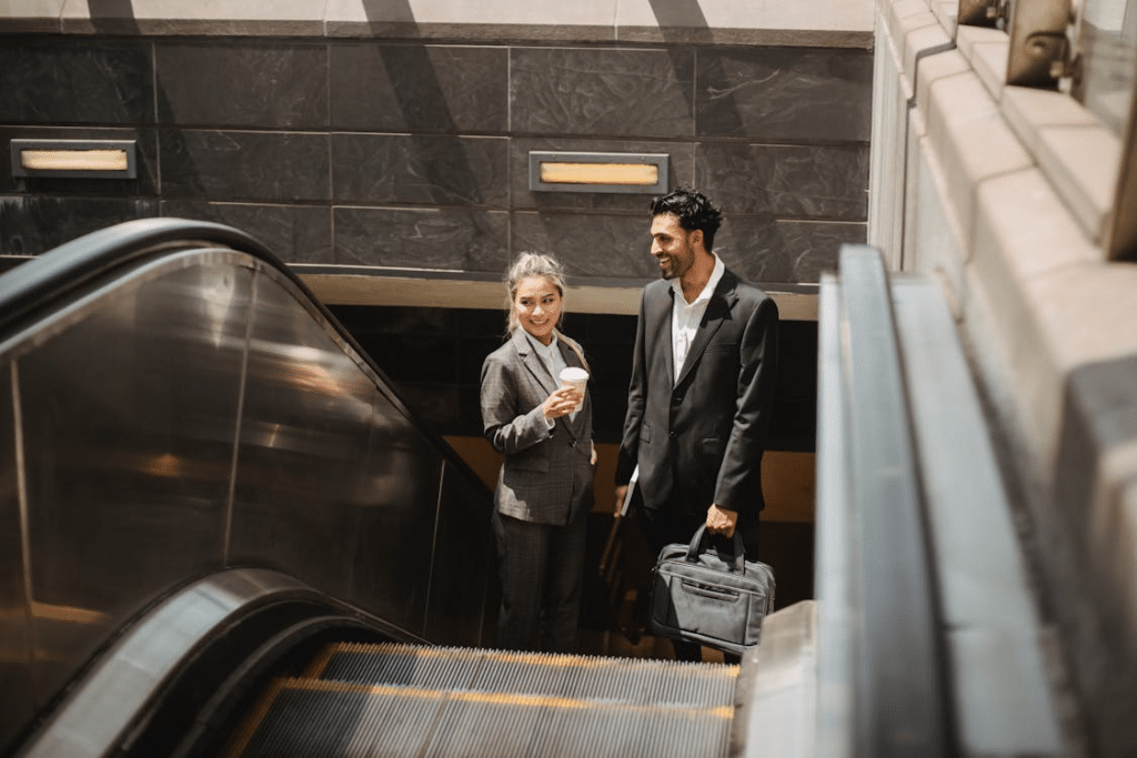 Man and Woman Standing on Escalator