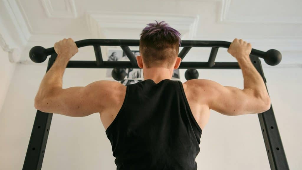 A man working out by doing chin ups.