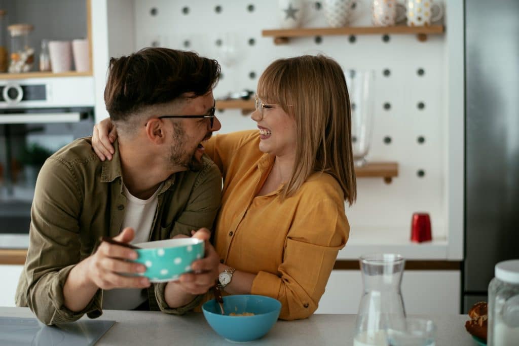 A young couple eating breakfast at home.