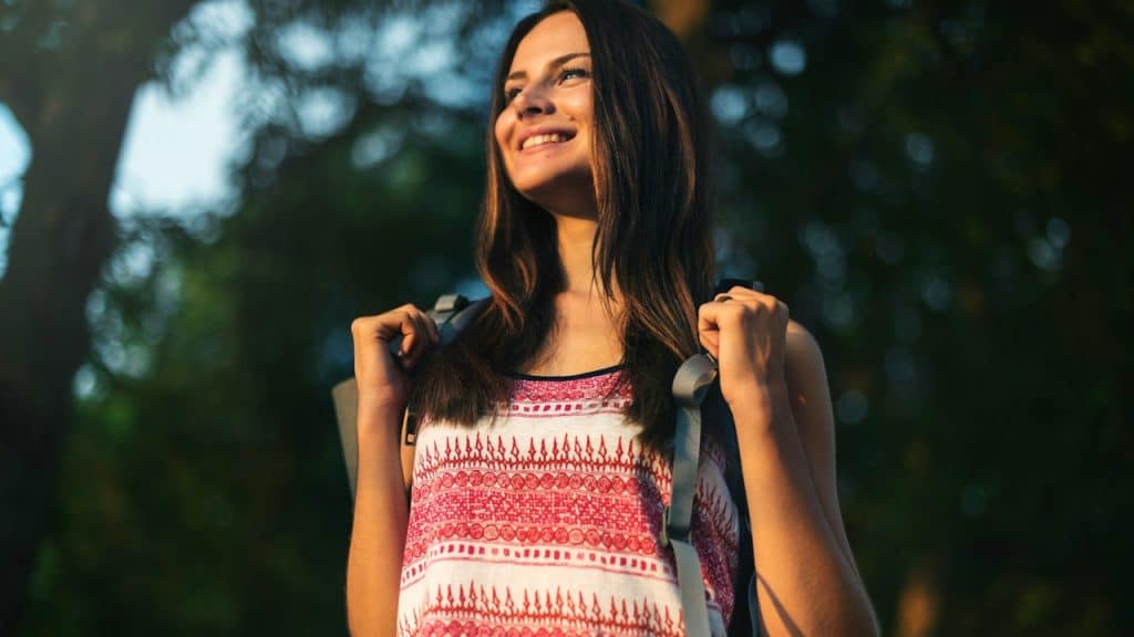 A passionate female traveler wearing a backpack.