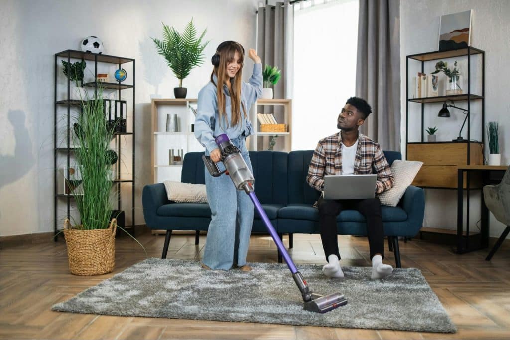 A woman busy cleaning and a man looking at her