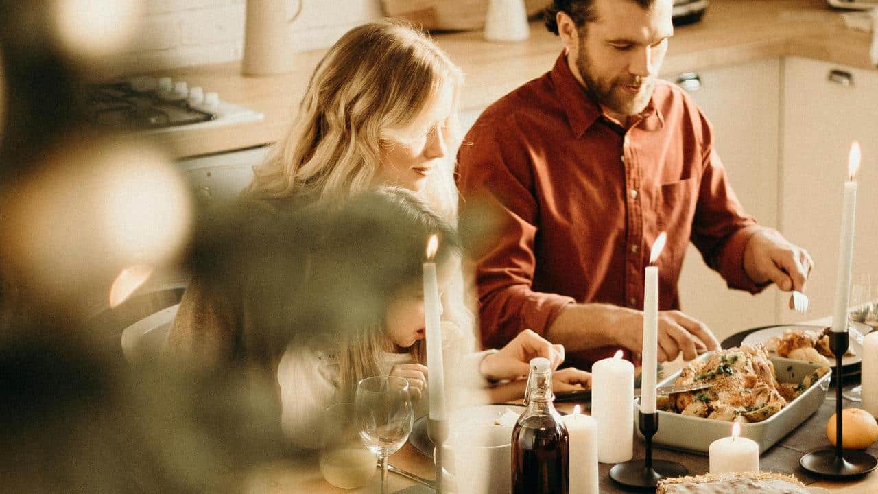 A family gathered around a candlelit dinner table.