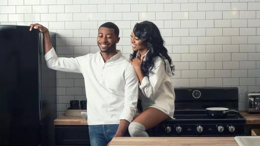 A smiling couple enjoying a moment together in a modern kitchen.