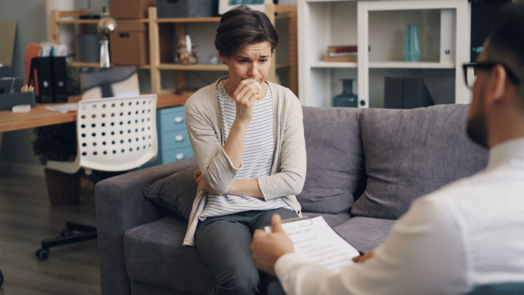 A man sitting on a couch talking to a woman