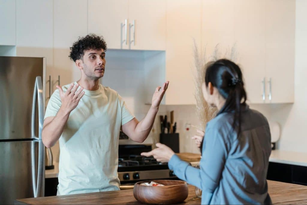 A man and woman arguing at the kitchen