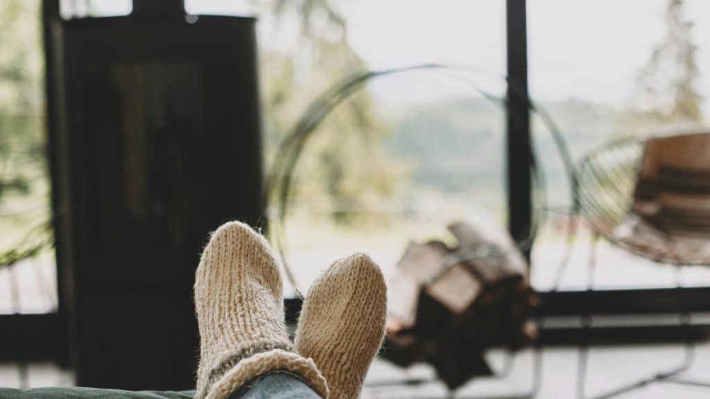 A person wearing knitted socks relaxing with their feet up.