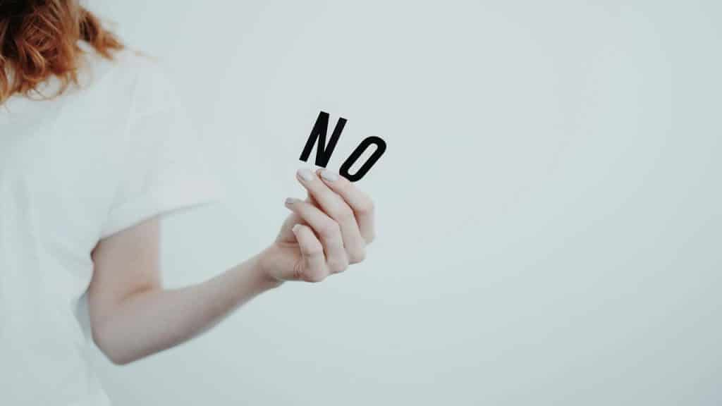 A woman holding letter spelling out “no” 