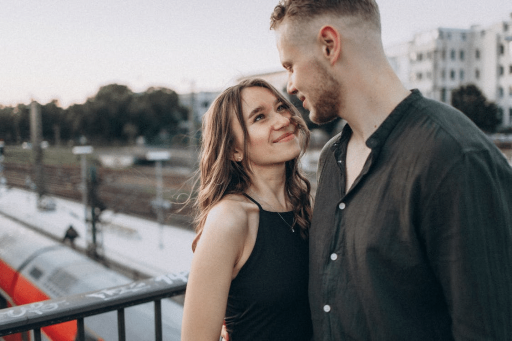 A couple standing on a bridge looking at each other