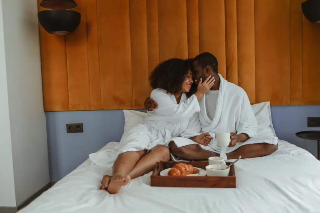 A couple wearing bathrobes on the bed