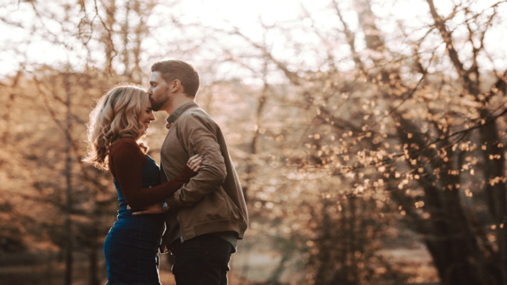 A man giving his girlfriend a forehead kiss
