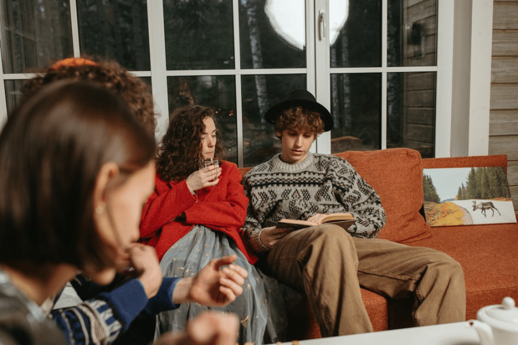 Man in Black and White Sweater Sitting on Brown Couch