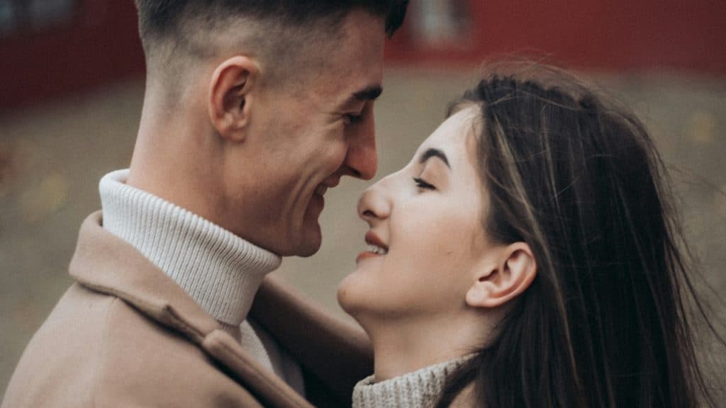 A man and woman looking lovingly at each other and about to kiss.
