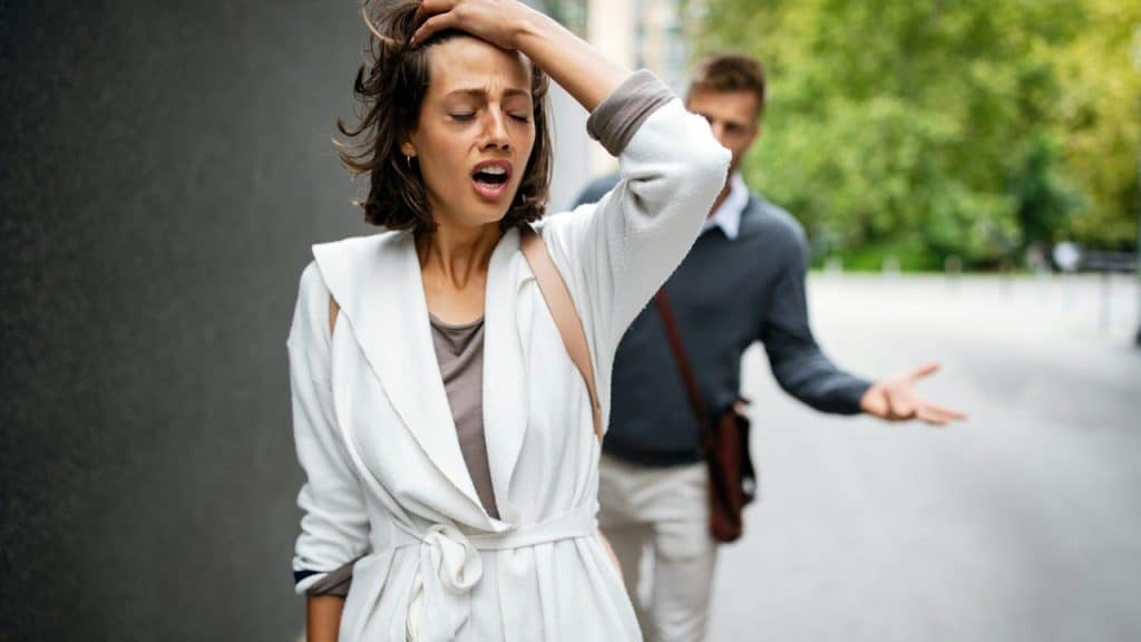 Frustrated couple arguing and having marriage problems outdoors.