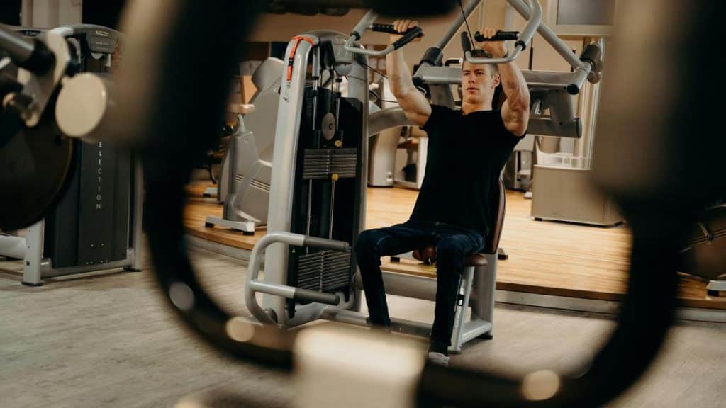 A man working out on a chest press machine in a gym.
