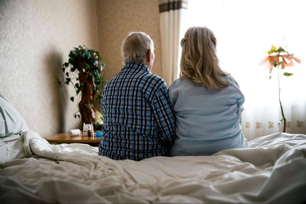 A couple sitting at the bed 