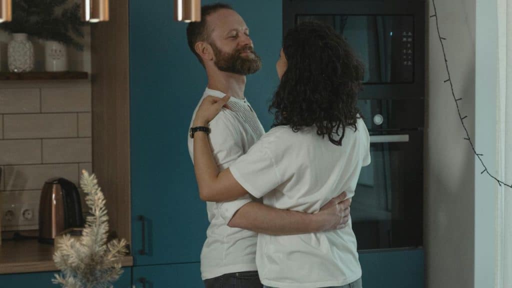 A couple dancing together in a kitchen.