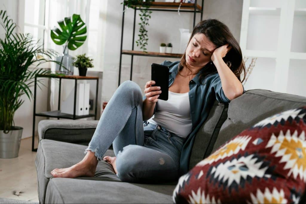 A man sitting at the sofa using a phone