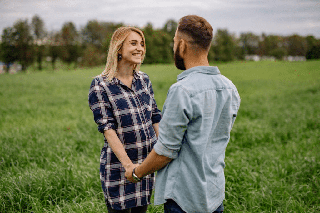 Couple Holding Hands while Standing on Green Grass