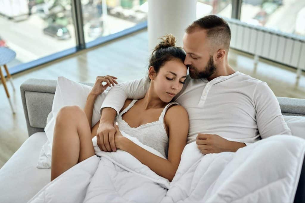 A man and woman at the bed