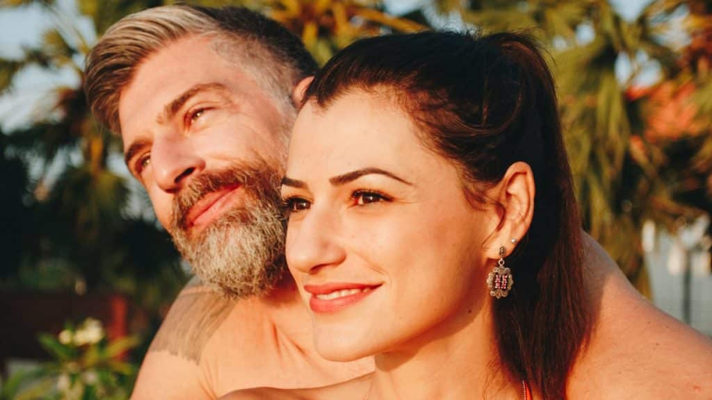A man and a woman in a swimming pool at a resort.