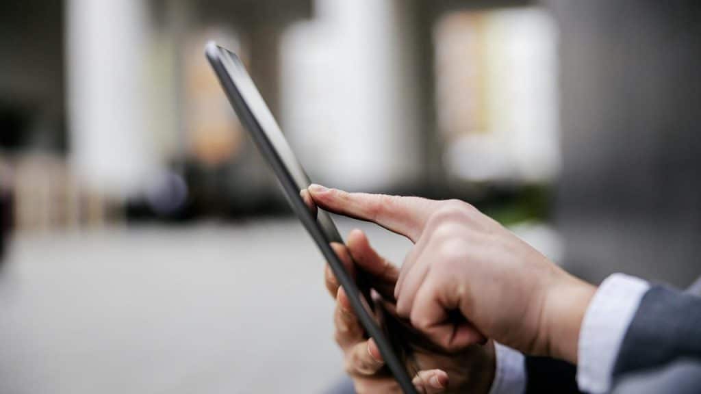 A person using a tablet outdoors.