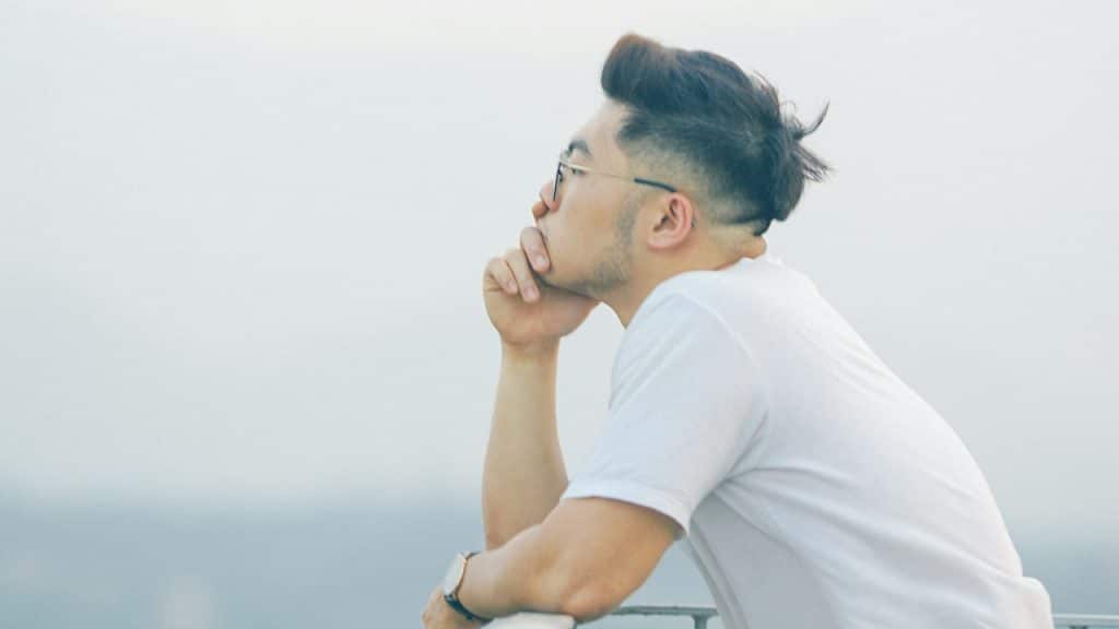 A man wearing glasses looking out over into the distance.