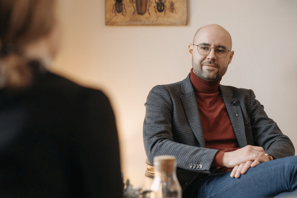 A Man in Gray Suit and Eyeglasses Sitting on a Chair
