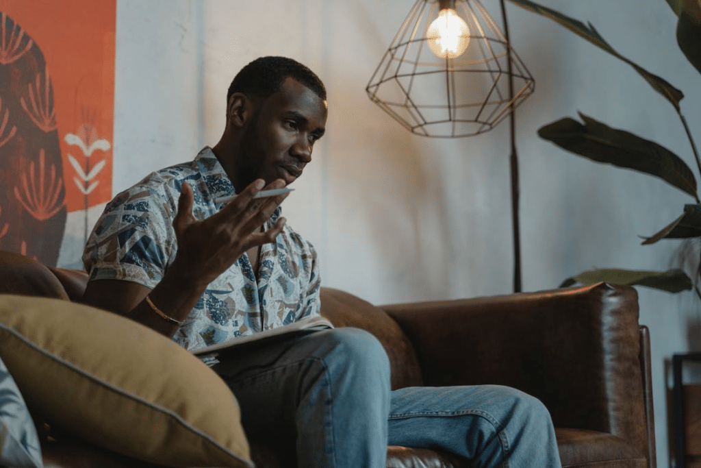 Man Sitting on Brown Leather Sofa While Thinking