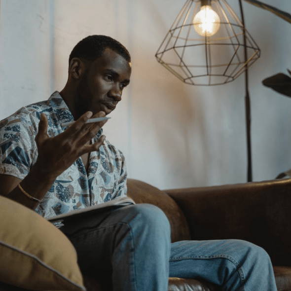 Man Sitting on Brown Leather Sofa While Thinking