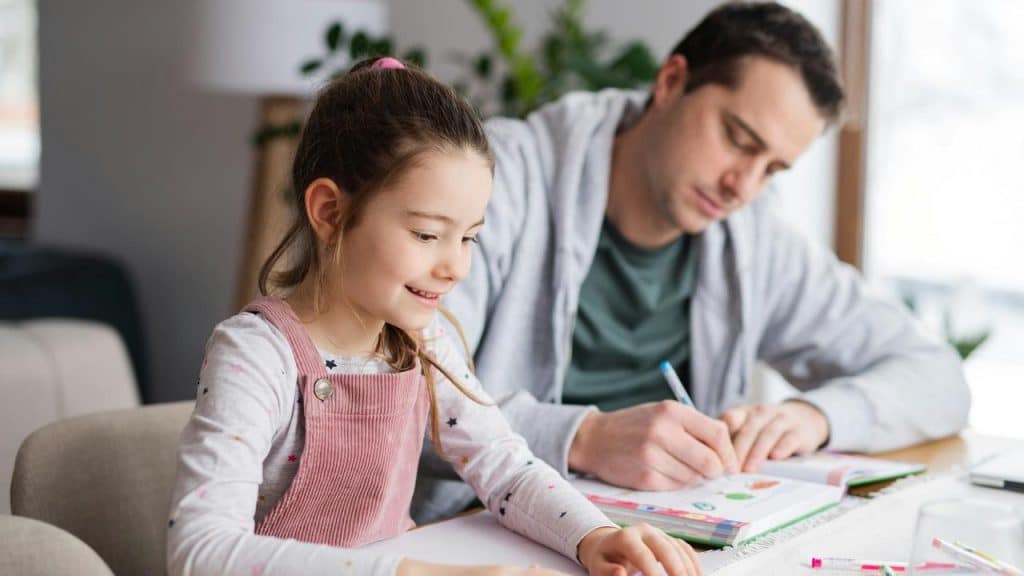 A father and her daughter doing homework together.