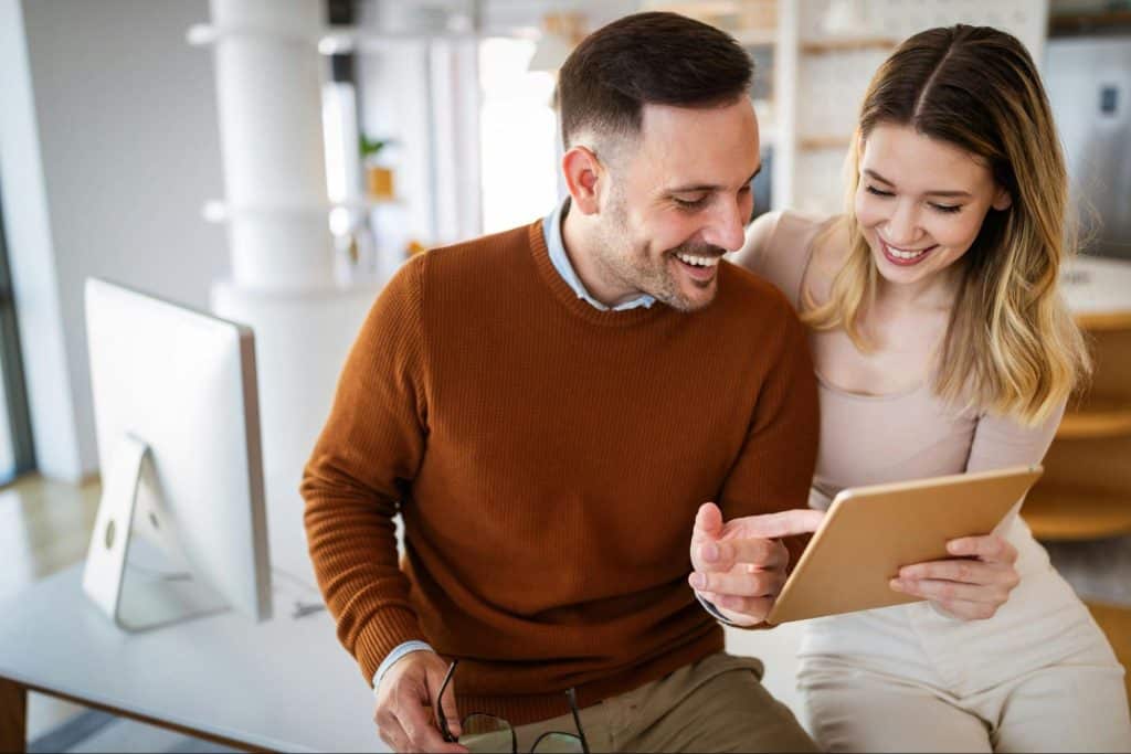 A man and woman looking at the tablet