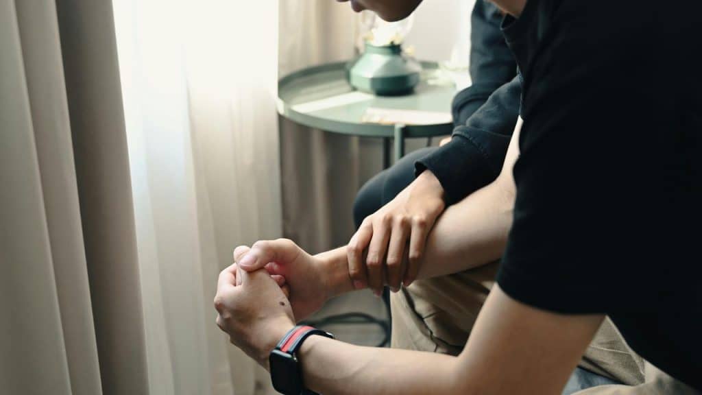 A person comforting another by holding their arm.