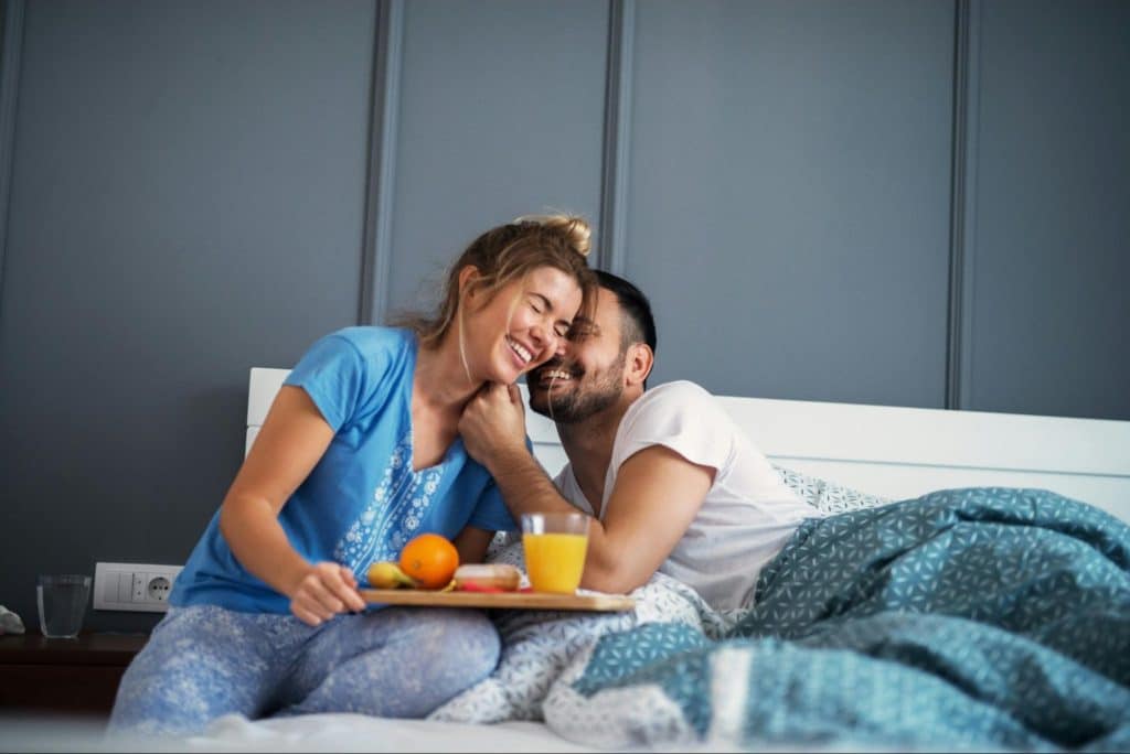 A man and woman at the bed