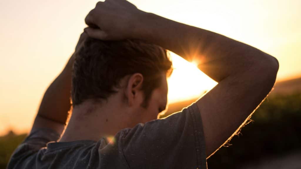 A man holding his hands on his head and looking worried.