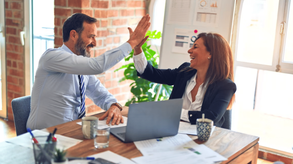 Colleagues high-fiving at work