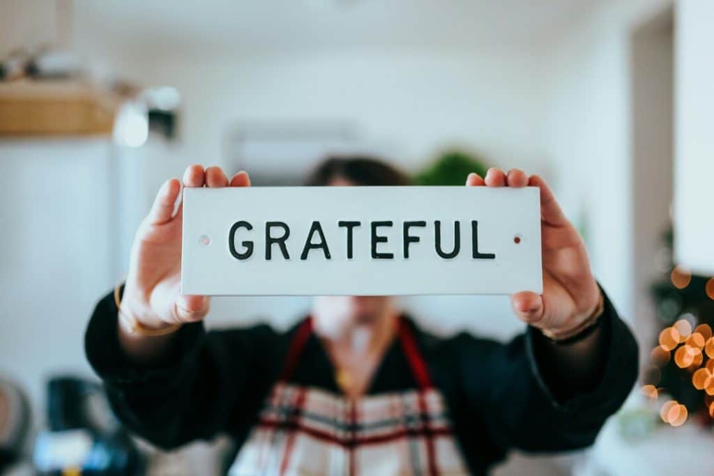 A person holding a “grateful” sign