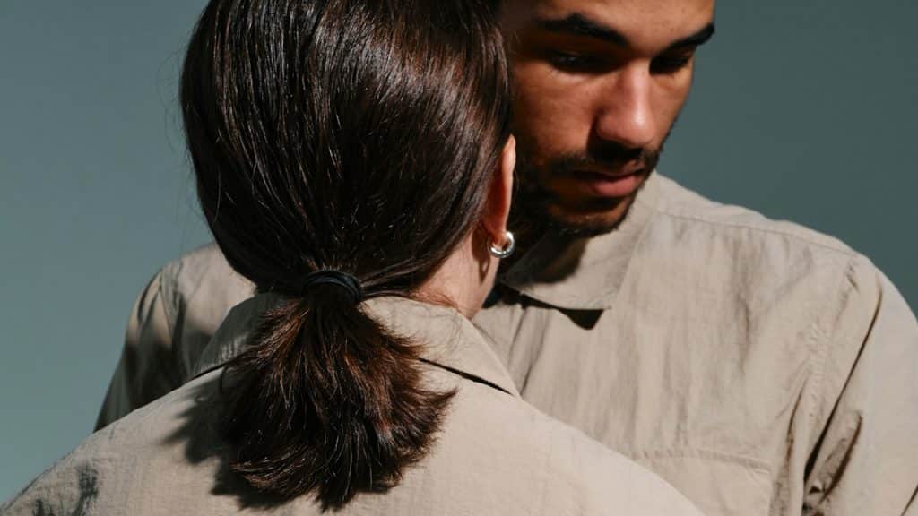 A man looking down while a woman stares at him.