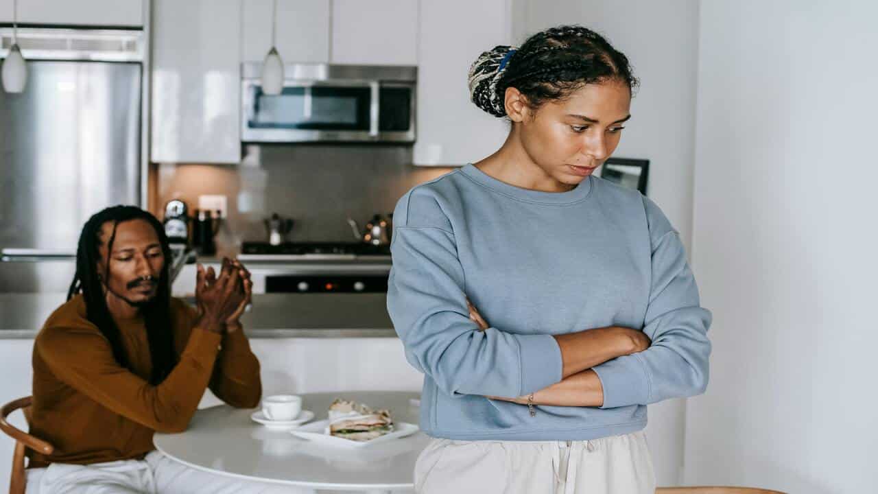 A couple looking upset at each other in the apartment